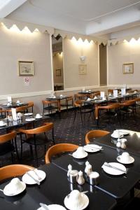 伦敦玫瑰园酒店的一间设有桌椅和帽子的餐厅