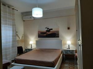 普罗斯西托角Villa Gisella的卧室配有一张床,墙上挂有绘画作品