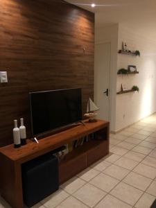 尼西亚弗洛雷斯塔Duplex Beira-mar em condomínio / Búzios-RN的客厅设有木墙,配有平面电视。