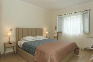蓬塔德尔加达Capelas Blue , Relax & Fun - Up to 14 Guests!的一间卧室设有一张大床和一个窗户。