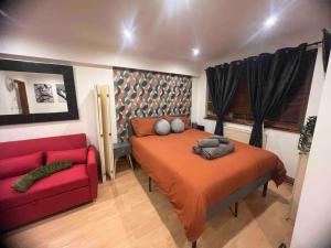 伦敦Nice StudioFLAT in London的一间卧室配有一张床和一张红色的沙发