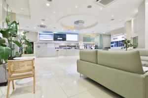 釜山Shire Hotel Seomyeon的医院大厅,配有沙发和桌子