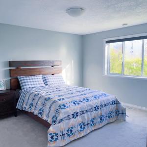 维多利亚Quiet Three Bedrooms House的一间卧室配有一张带蓝色和白色棉被的床