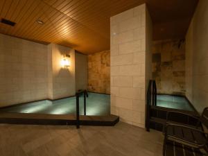 京都Loisir Hotel Kyoto Toji的一座带瓷砖墙的建筑中的游泳池