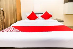 阿加尔塔拉OYO Hotel Sonar Gaon的红色和白色的床,上面有红色枕头