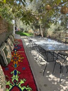 代姆纳特Dar assounfou的人行道上一张桌子和椅子,上面有五颜六色的地毯