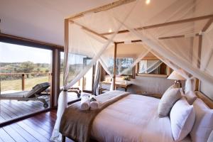 CaperteeTuron Gates - Mountain Retreat的一间卧室设有一张天蓬床和一个阳台