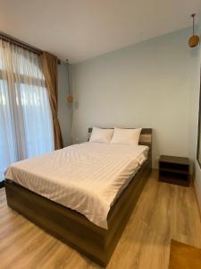 富国Lana Inn - Grand World Phú Quốc的一间卧室配有一张带白色床单的大床