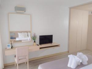迈考海滩D Varee Mai Khao Beach Resort, Thailand的一间卧室配有一张床和一张书桌上的电视