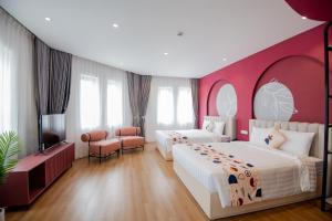 下龙湾Palette Collect's Boutique Hotel Ha Long的一间卧室设有两张床和粉红色的墙壁