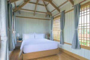潘切K-Town Resort Phan Thiet的卧室配有白色的床和2扇窗户。