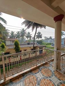 库斯哈尔纳加尔Charan's Homestay的阳台享有建筑和棕榈树的景致。