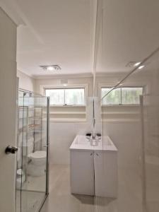 Doncaster EastPeaceful location 3BR WiFi/Netflix/Kitchen的白色的浴室设有水槽和淋浴。