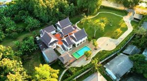 清迈Phi Private Villa: Luxury Thai with Riverview的享有带游泳池和树木的房屋的空中景致