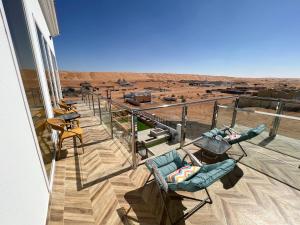 Al RakaR61 Sunrise Chalet的阳台配有椅子,享有沙漠美景