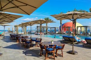 好莱坞Luxurious 2 bedroom on the Ocean IL的一个带游泳池、桌子和遮阳伞的度假村