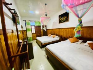 哈普特莱Srilak View Holiday Inn的带两张床和两个窗户的房间