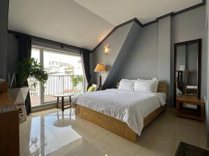 大叻CozyNook Boutique Apartments - 3 thang 2 Street的一间卧室设有一张床和一个大窗户