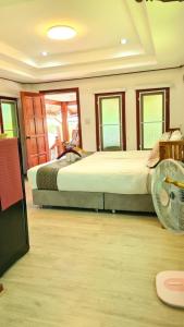 南邦Lampang Hideaway Guesthouse的一间卧室配有两张床和风扇