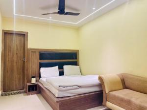 贾姆穆Hotel Himgiri Pakki Daki的一间卧室配有一张床和一张沙发
