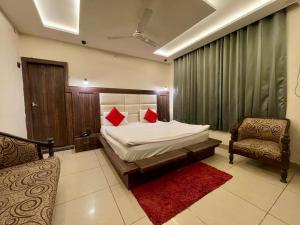 贾姆穆Hotel Himgiri Pakki Daki的一间卧室配有一张带红色枕头的床和一把椅子