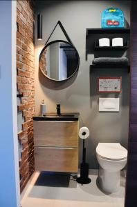 莫斯塔Chic Penthouse industrial-style的一间带水槽、镜子和卫生间的浴室
