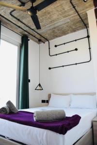 莫斯塔Chic Penthouse industrial-style的一间卧室配有一张带紫色床单的大床