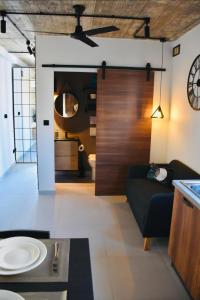 莫斯塔Chic Penthouse industrial-style的客厅配有沙发和墙上的时钟
