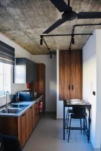 莫斯塔Chic Penthouse industrial-style的厨房配有木制橱柜和桌椅