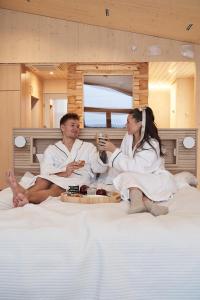 库奥皮奥Bella Lake Resort的坐在床上吃着食物的男人和女人