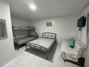 阿拉米诺斯Nolina's Transient Rooms - Alaminos, Pangasinan的客房设有两张床和一张双层床。