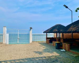 莫龙Hana Natsu Resorts Beach & Hotel的一个带栅栏的海滩和一个带门的建筑