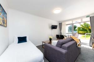奥克兰阿兰吉汽车旅馆的一间卧室配有一张床、一张沙发和一个窗口