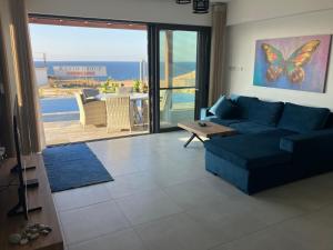 KalogreaBungalow med privat saltvannsbasseng på Dejablue的客厅配有蓝色沙发,享有海景