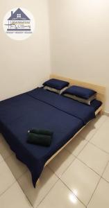 加央HOMESTAY haROOManizz的一张带蓝色床单和两个绿色枕头的床