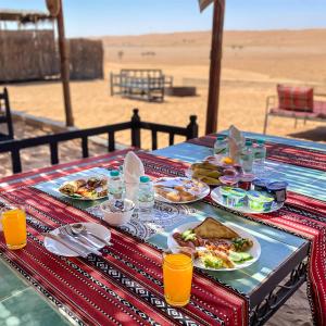 Al QābilSAMA Al Areesh Camp的海滩上一张带食物盘的桌子