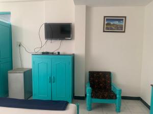 马焦茹达Shangrila by Craftels的一间设有蓝色橱柜、椅子和电视的客房