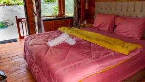 龙目岛库塔Mandalika Queen Hostel的一张带粉红色棉被和两个枕头的床