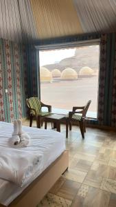 瓦迪拉姆Yellow Star Camp Wadi Rum的卧室配有一张床和一张桌子及椅子