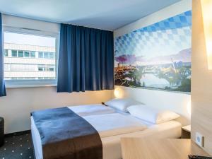 慕尼黑北慕尼黑城市住宿加早餐旅馆的酒店客房设有一张床和一个大窗户