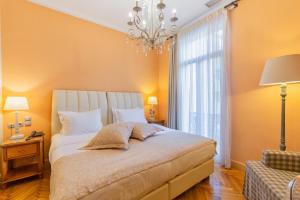 雅典美家园酒店的一间卧室配有一张大床和一个吊灯。