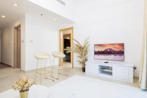 迪拜Luxury and spacious full Marina view的客厅设有2张凳子和1台墙上的电视
