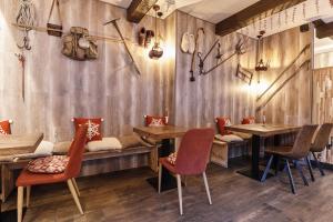 奥尔迪诺拉尼优公寓的餐厅拥有木墙和木桌及椅子