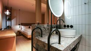 孙登西加藤酒店的一间带水槽和镜子的浴室