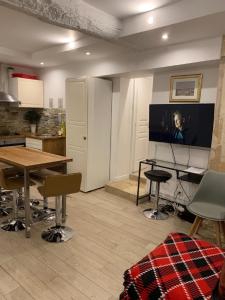 巴黎阿特利尔蒙特吉尔19号公寓的客厅配有桌子和平面电视。