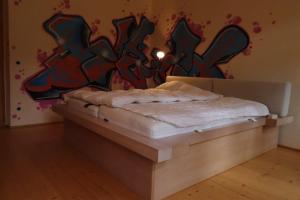 因斯布鲁克Haus Tanegg的一张位于带涂鸦墙的房间的床铺