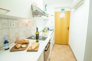 乌马格Umag center apartment parking rentistra的厨房配有带面包和一瓶葡萄酒的吧台