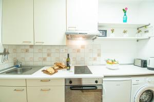 乌马格Umag center apartment parking rentistra的厨房配有白色橱柜、水槽和洗碗机。