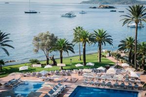 伊维萨镇THB罗斯蒙里诺酒店 - 仅限成年人的一个带游泳池、椅子和棕榈树的度假村