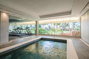 伊维萨镇THB罗斯蒙里诺酒店 - 仅限成年人的一座带大窗户的房屋内的室内游泳池